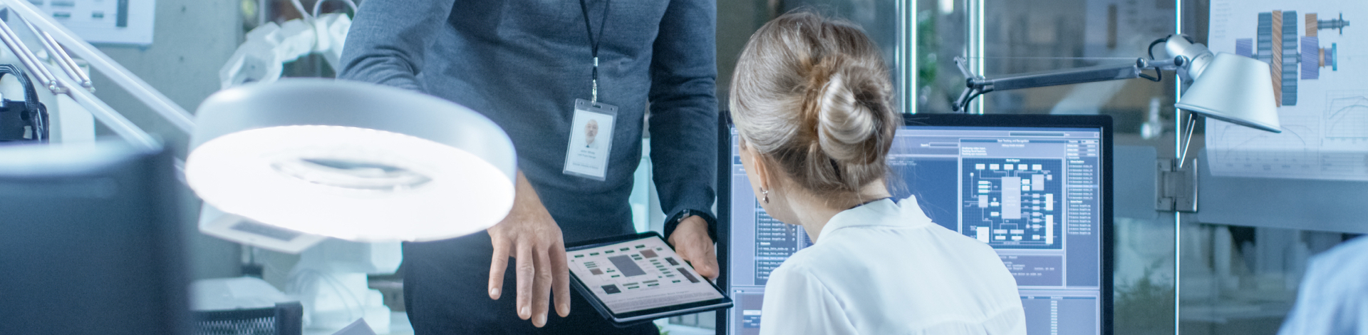 man and woman talking infront of computer and tablet